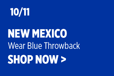 Boise State Football graphic on royal-blue background. White text reads: '10/11 New Mexico' with subtext 'Wear Blue Throwback' and 'SHOP NOW >'.