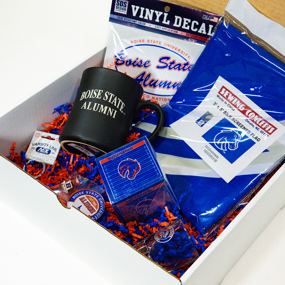 Open Boise State Alumni gift box showing the mug, flag, sticky note cube, pin, magnet, keychain, and alumni decal inside.