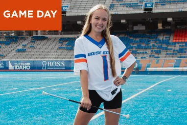 Mobile Game Day image with a student in a white jersey on the blue turf. Tap to shop Game Day gear.