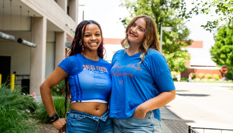 Two Boise State students wearing Boise State Blue and Orange apparel on campus